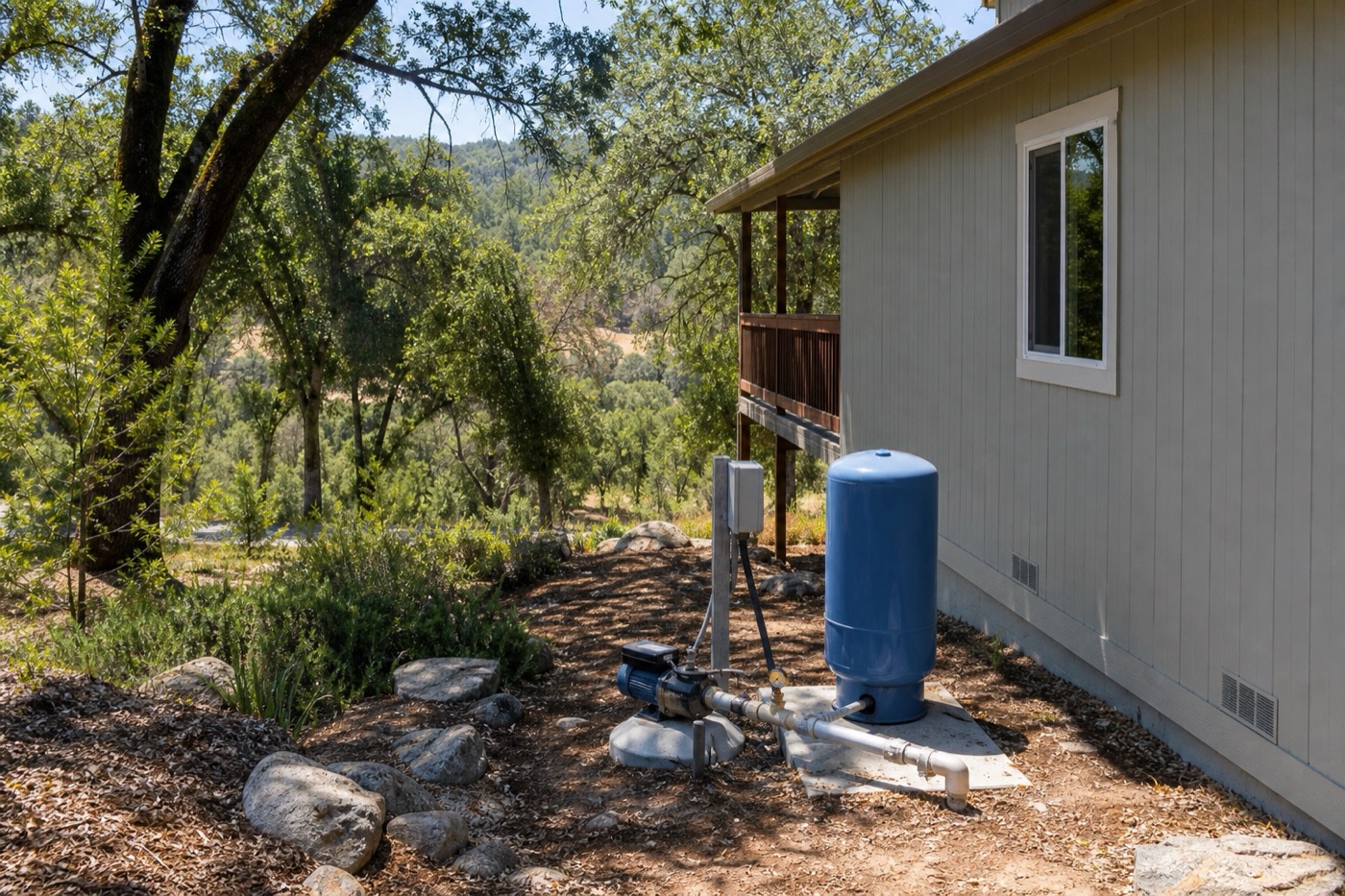 Private well pump and pressure tank beside a California home